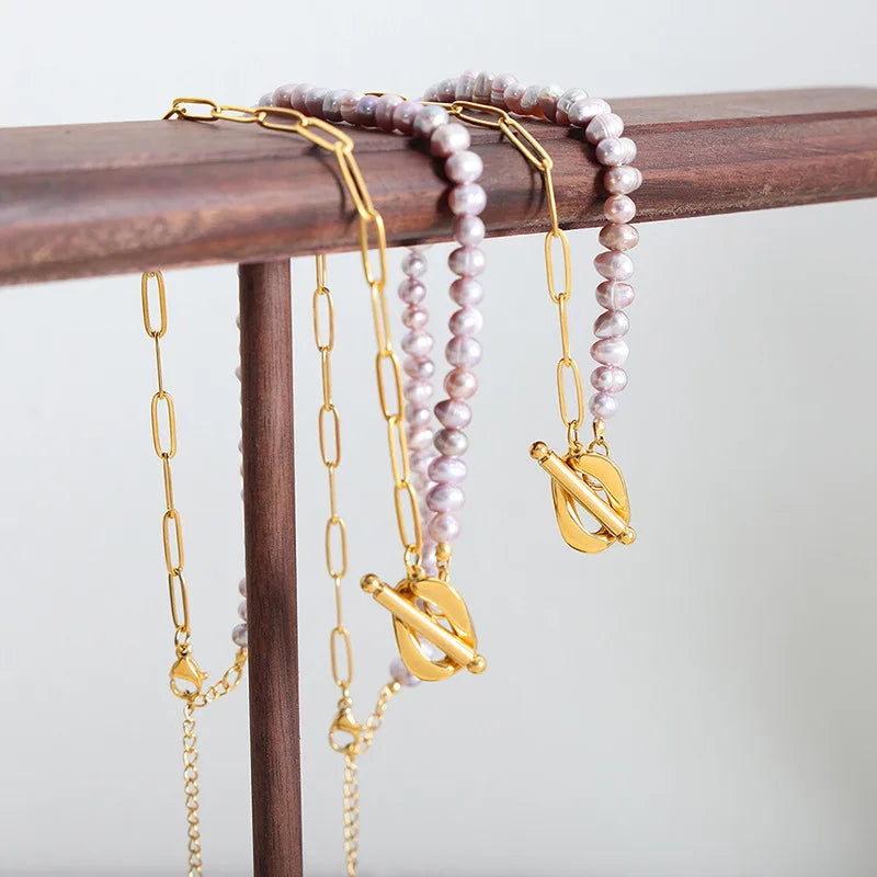 Paperclip and Pearl T Bar necklace in Gold with simulated freshwater pearls in a soft pink colour.