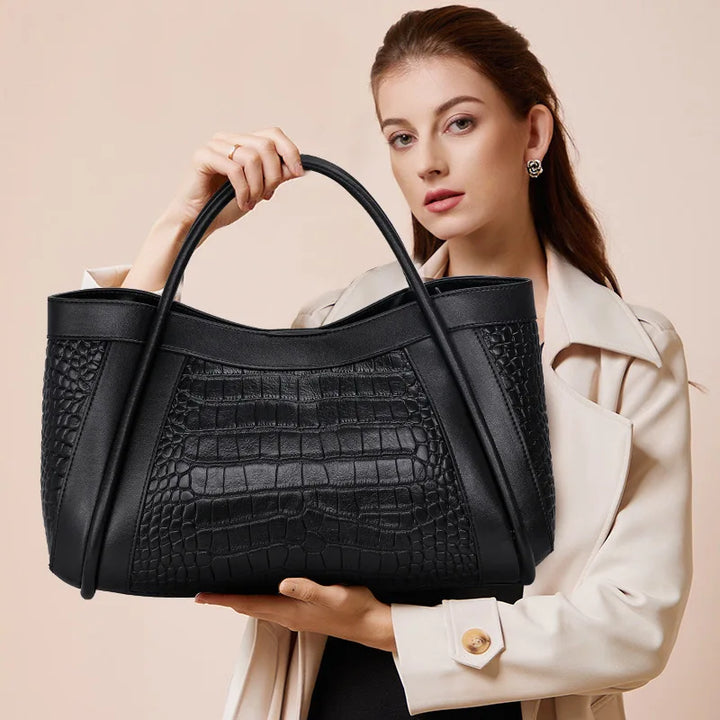 The Megyn Tote Bag in Black is an East/West style featuring rolled top grab handles and seamed detail.