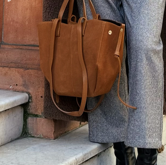 Soho Midi Tan Suede Tote Bag with dual grab handles and long shoulder straps being held by a woman