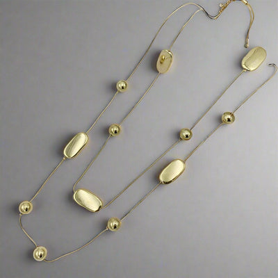 Our beautiful Fallon necklace is a double strand station necklace featuring flat polished zinc alloy ovals and spheres on a matching cord.&nbsp; Black, Gold or Silver.